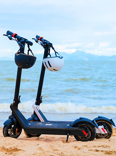 A black and white 850 watt pro electric scooter setting at the beach